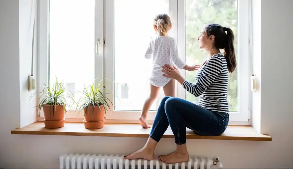 Family keeping warm at home by a radiator